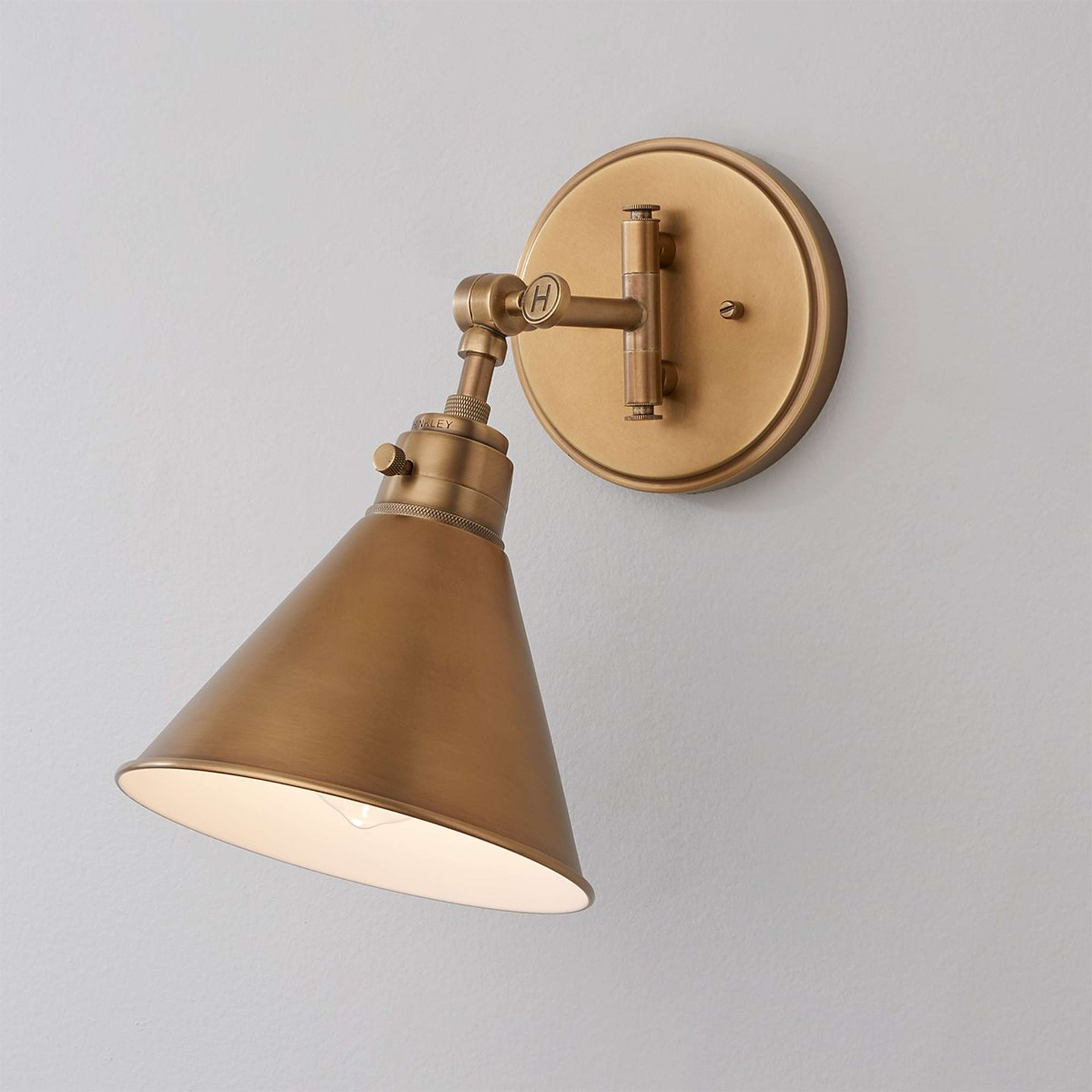 A Cyrus Swing Arm Sconce - Metal Shade with Aged Brass color