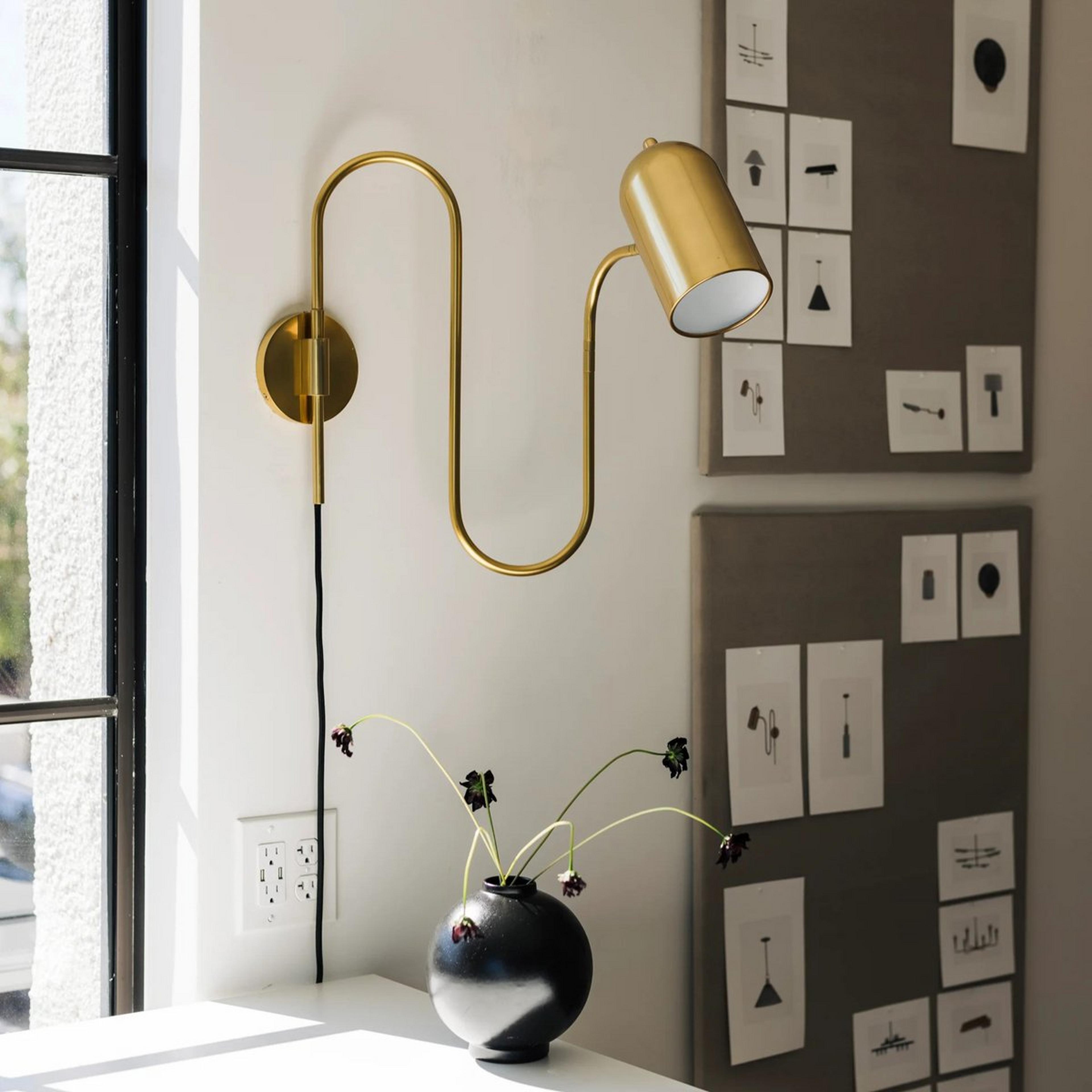 A Gilmer Swing Arm Sconce with Brass color
