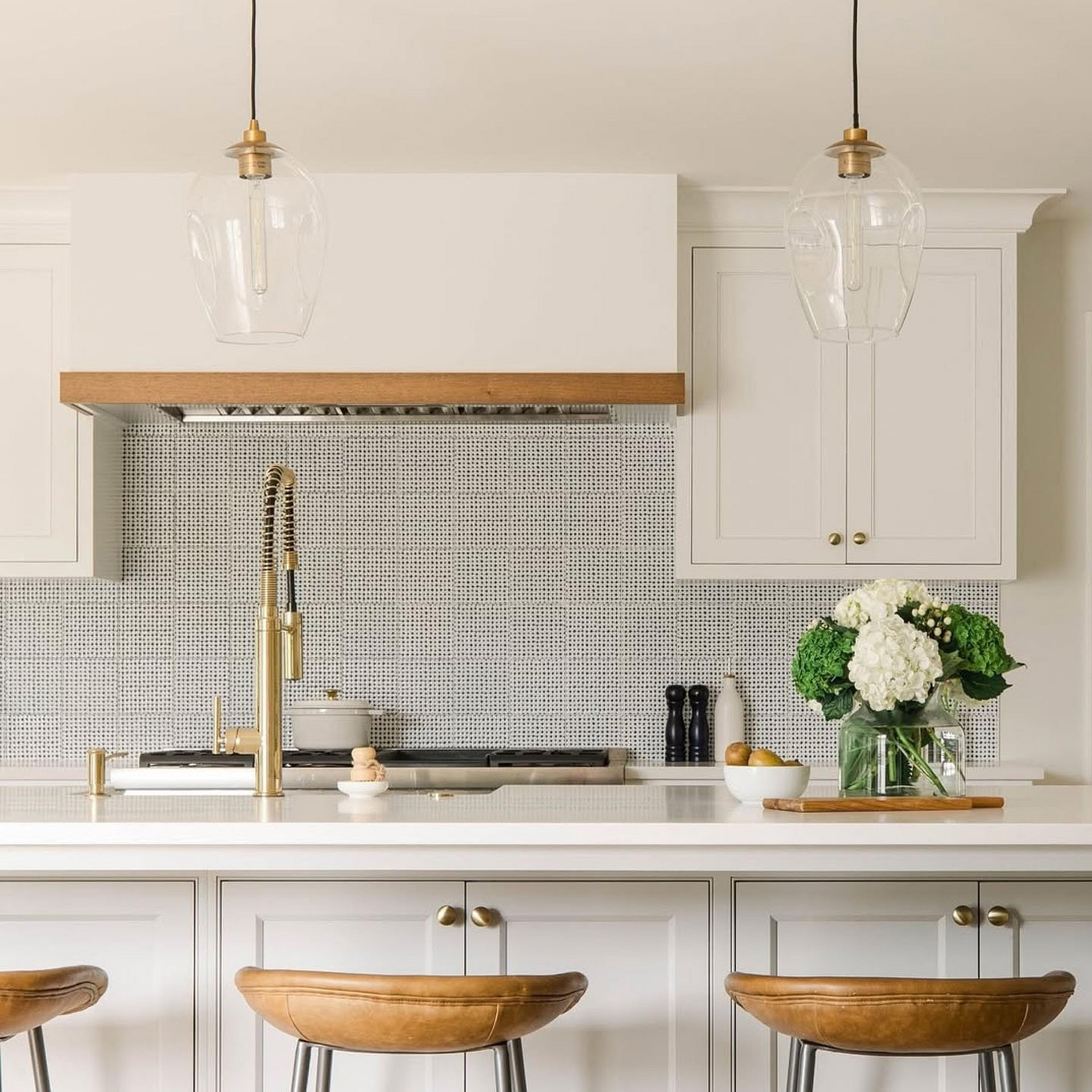 Two brass serene swell pendants over a kitchen island with wooden stools