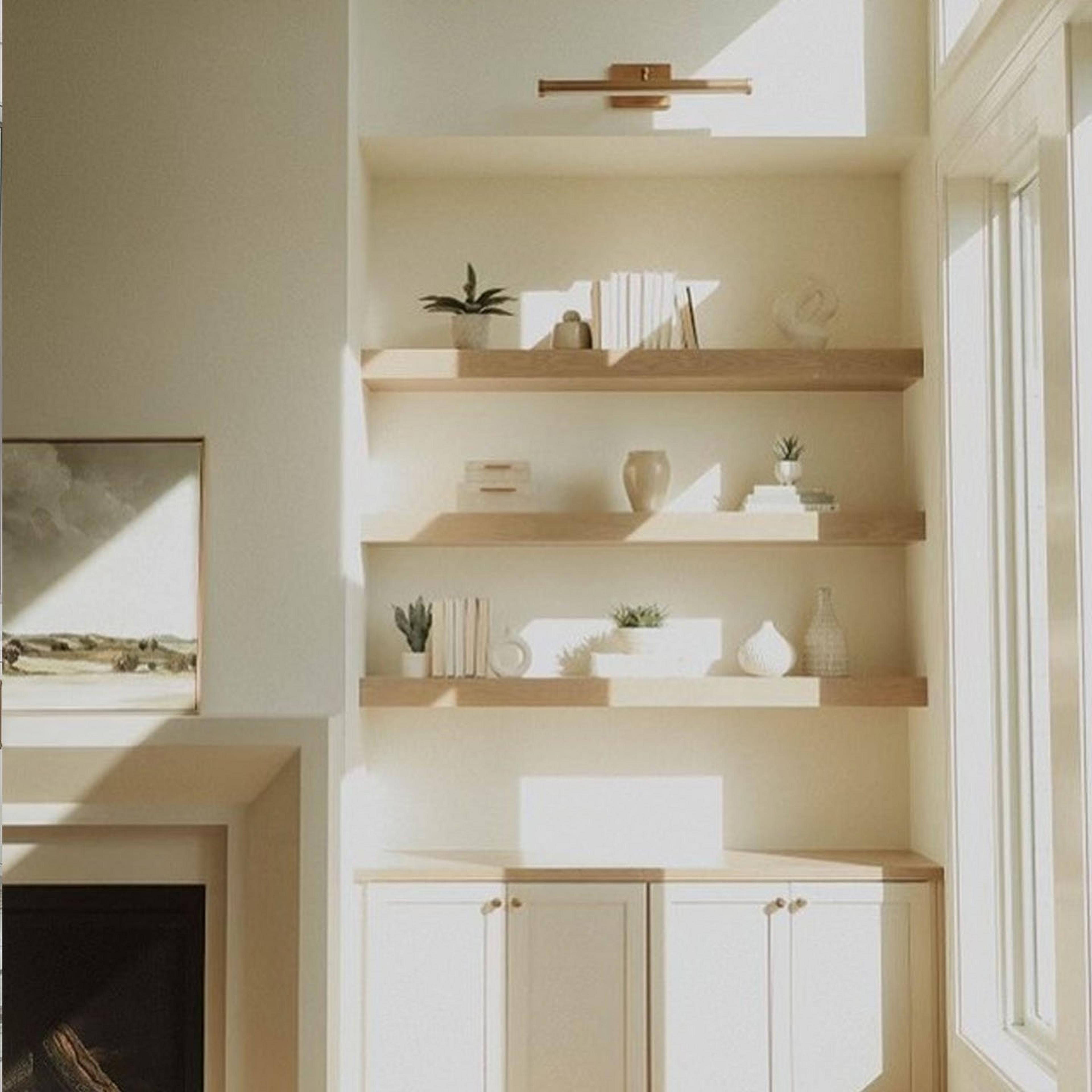 An antique brass picture light over a stylized shelf