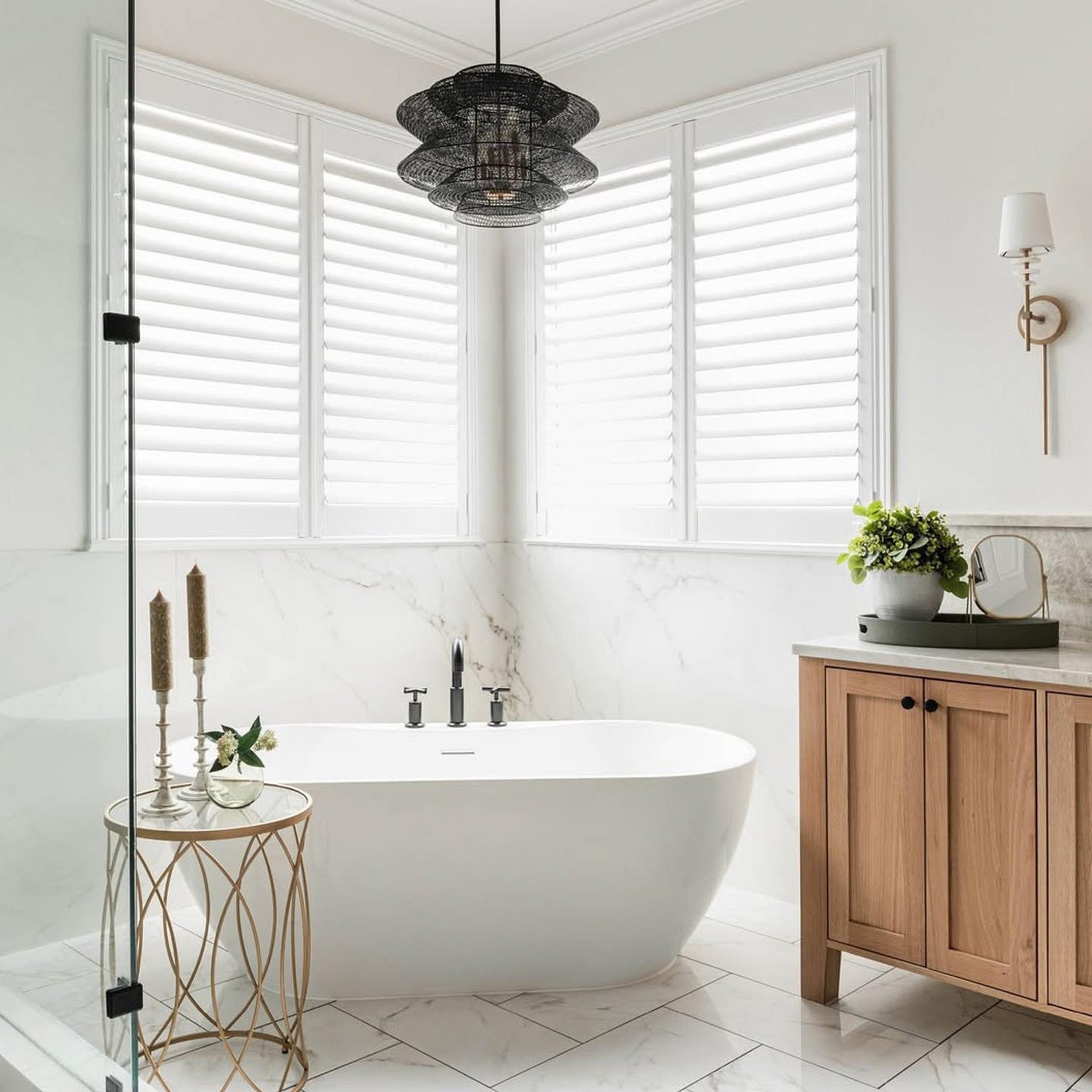 Dark bronze ripple mesh lantern hangs over a simple white tub