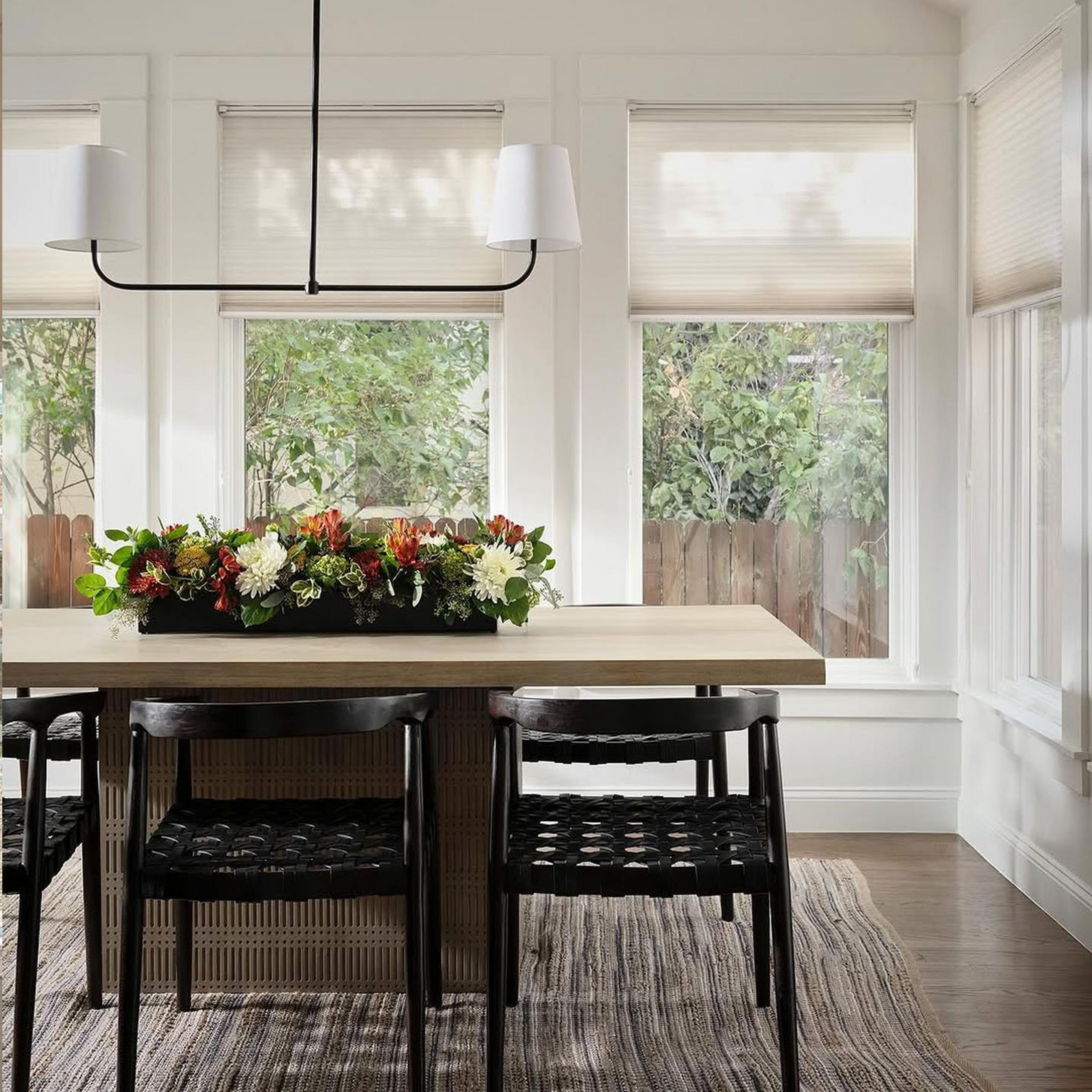 A matte black Westchase Island Chandelier offers a minimalistic design in a simple dining area
