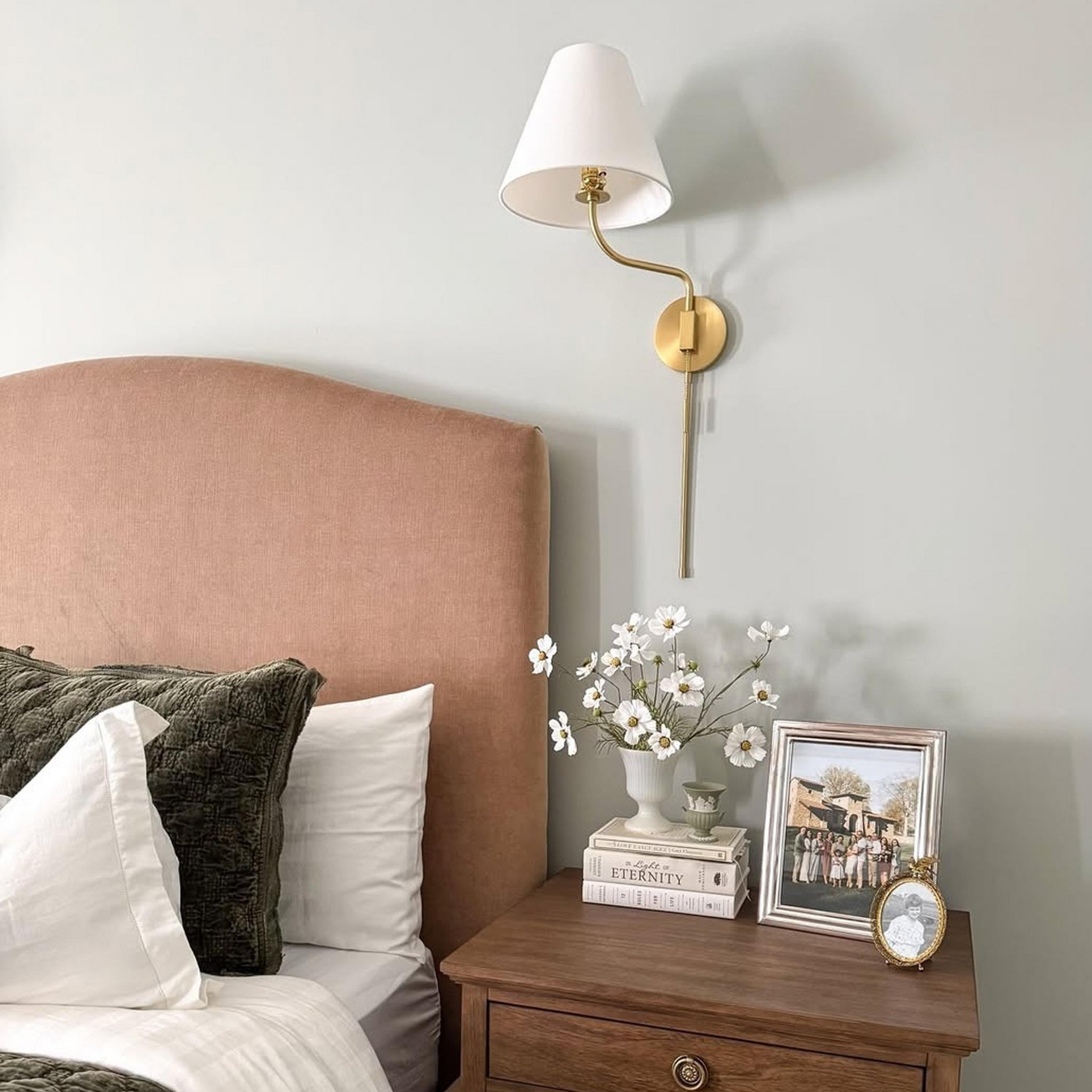 Transitional Swing Arm Sconce⁠ beside a bed