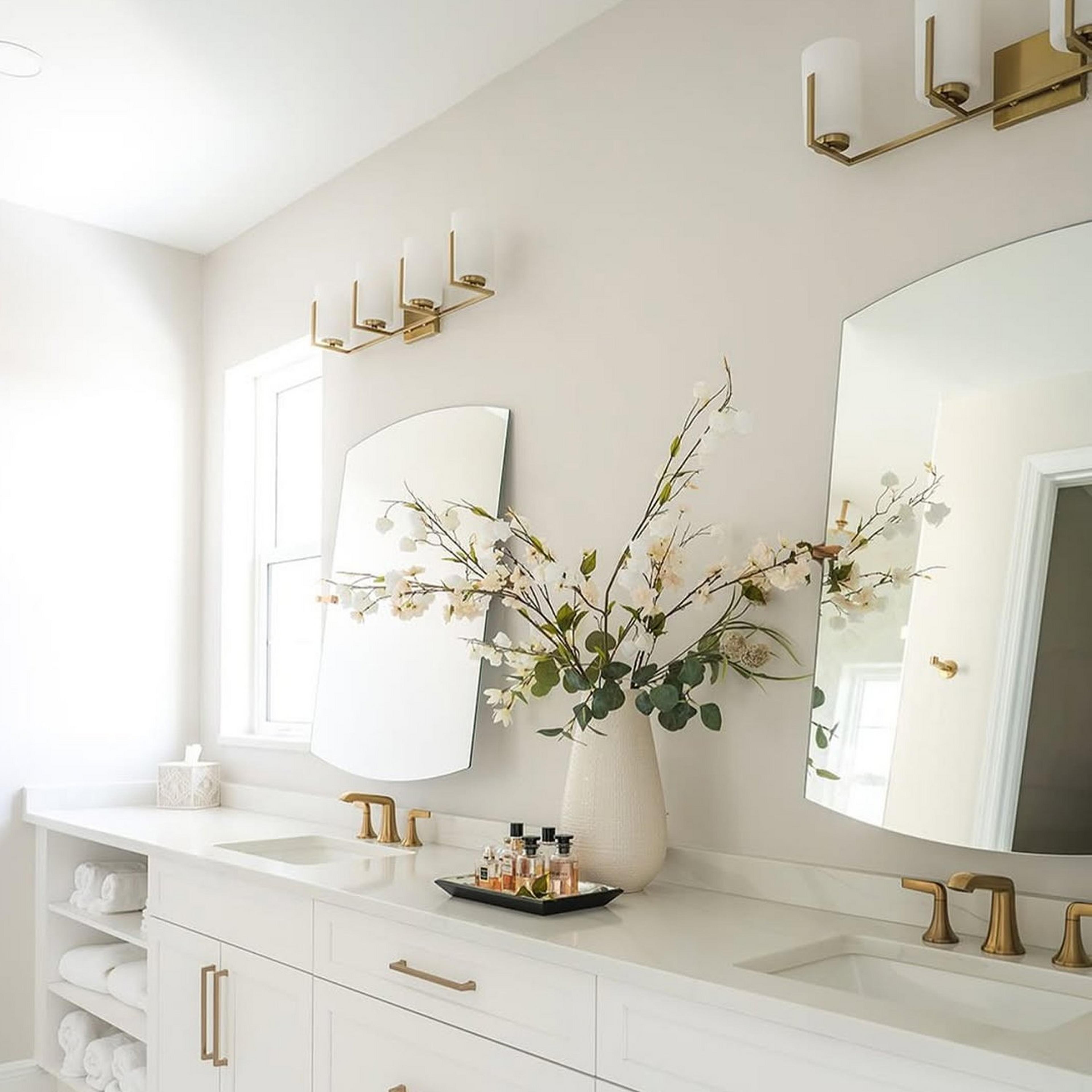 Satin Brass Arrow Vanity Light in light bathroom