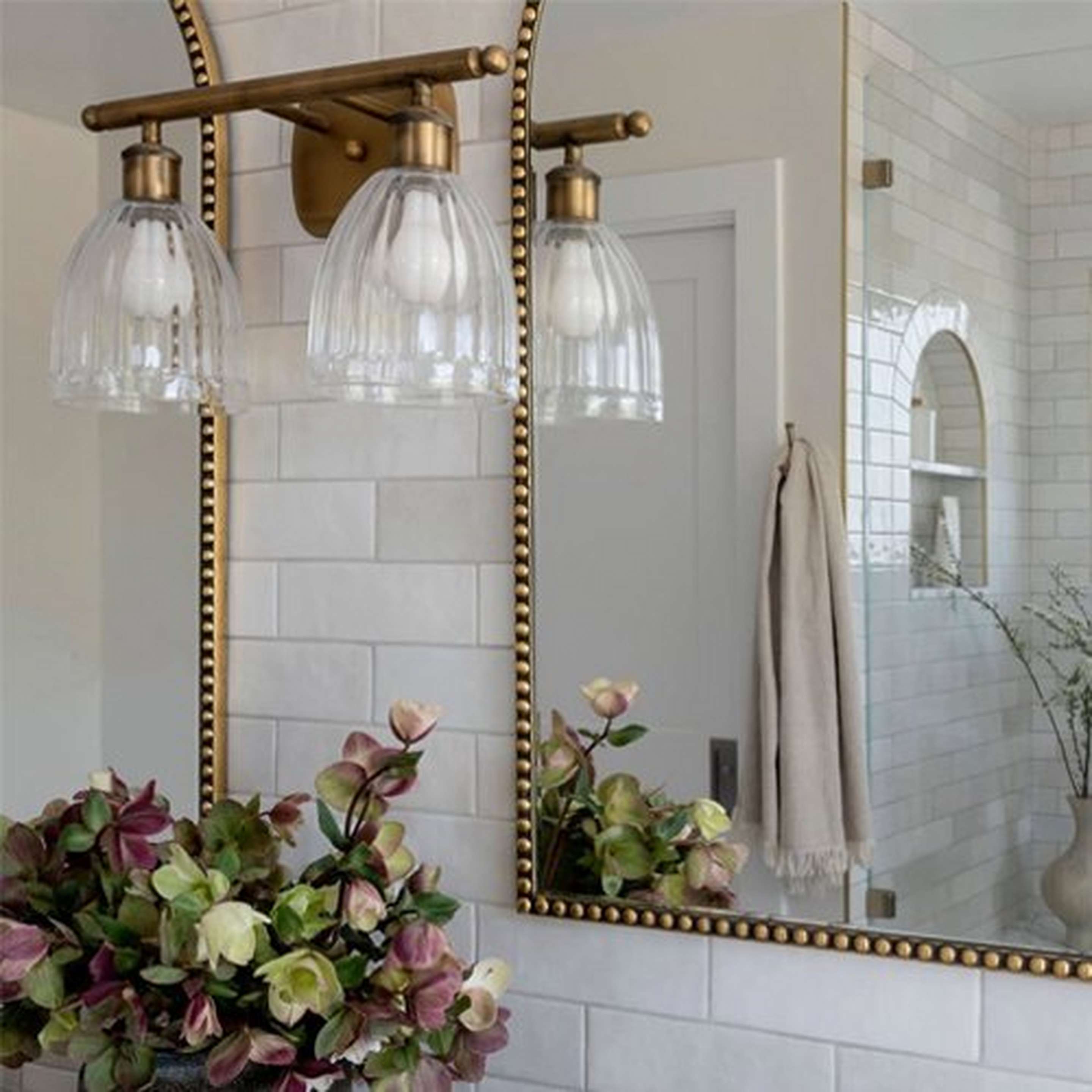 Vintage Update Vanity Light beside a gold arched mirror