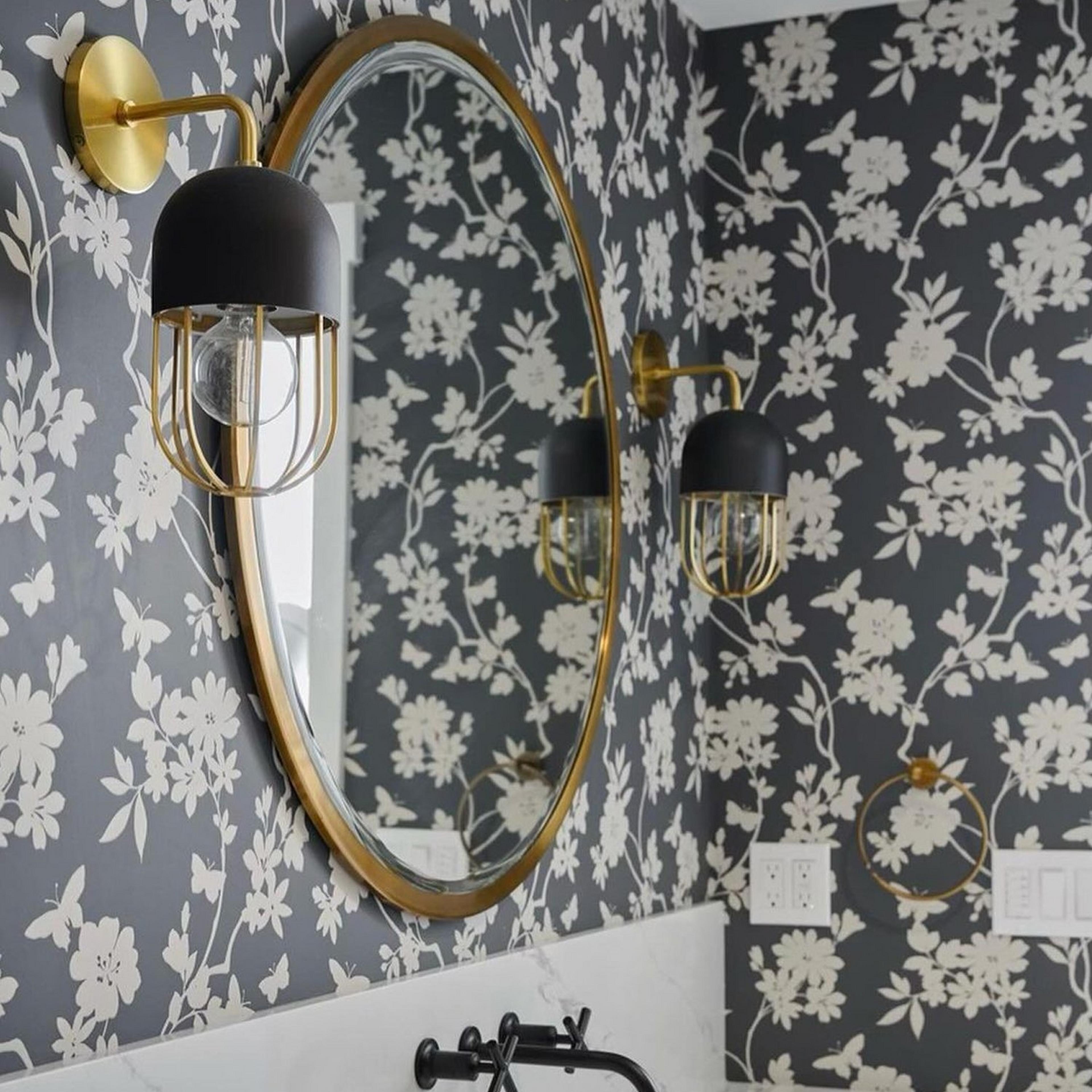 Brushed brass  Capsule Cage Sconces in a bathroom with floral wallpaper