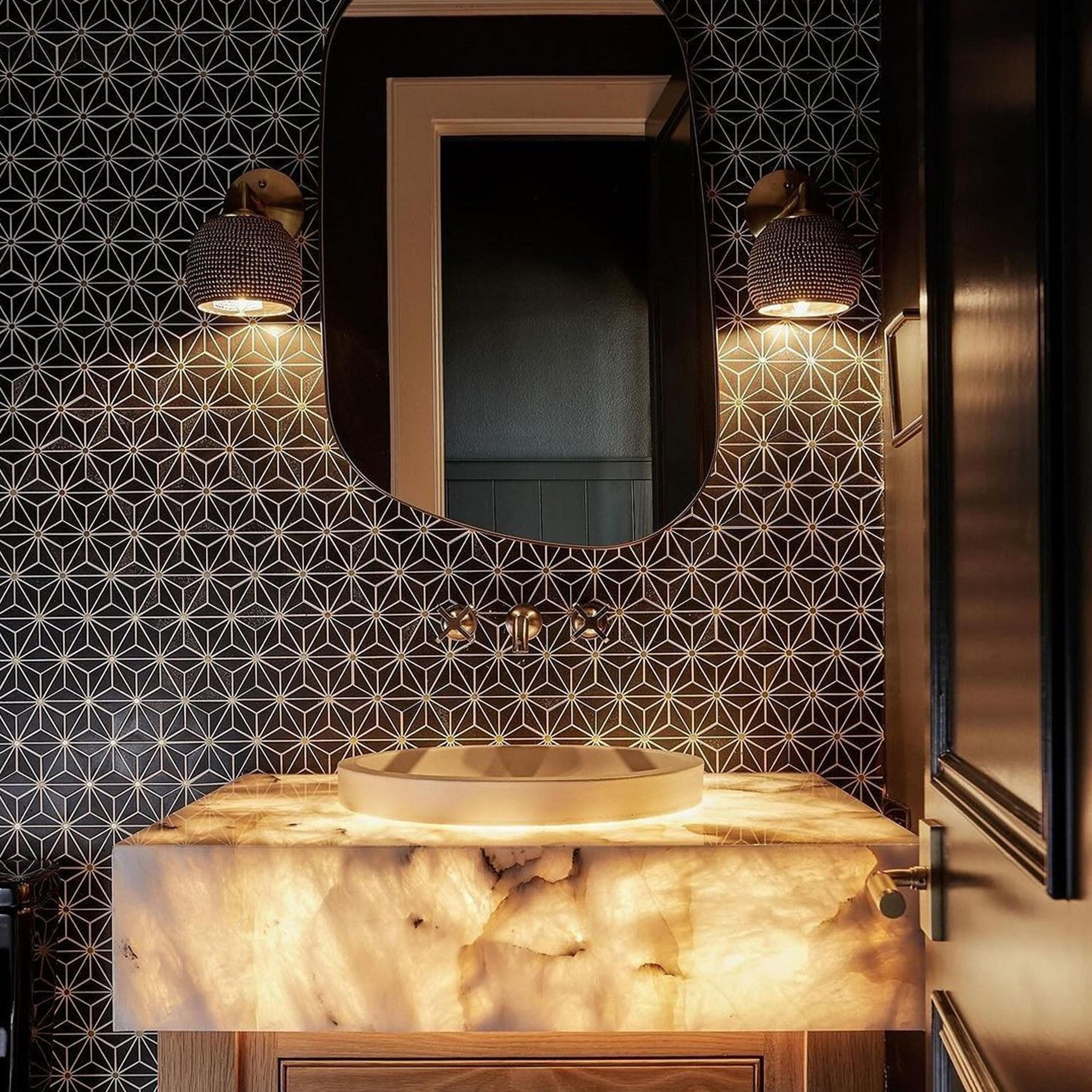Two Studded Brass Sconces in a bathroom with lit counter top