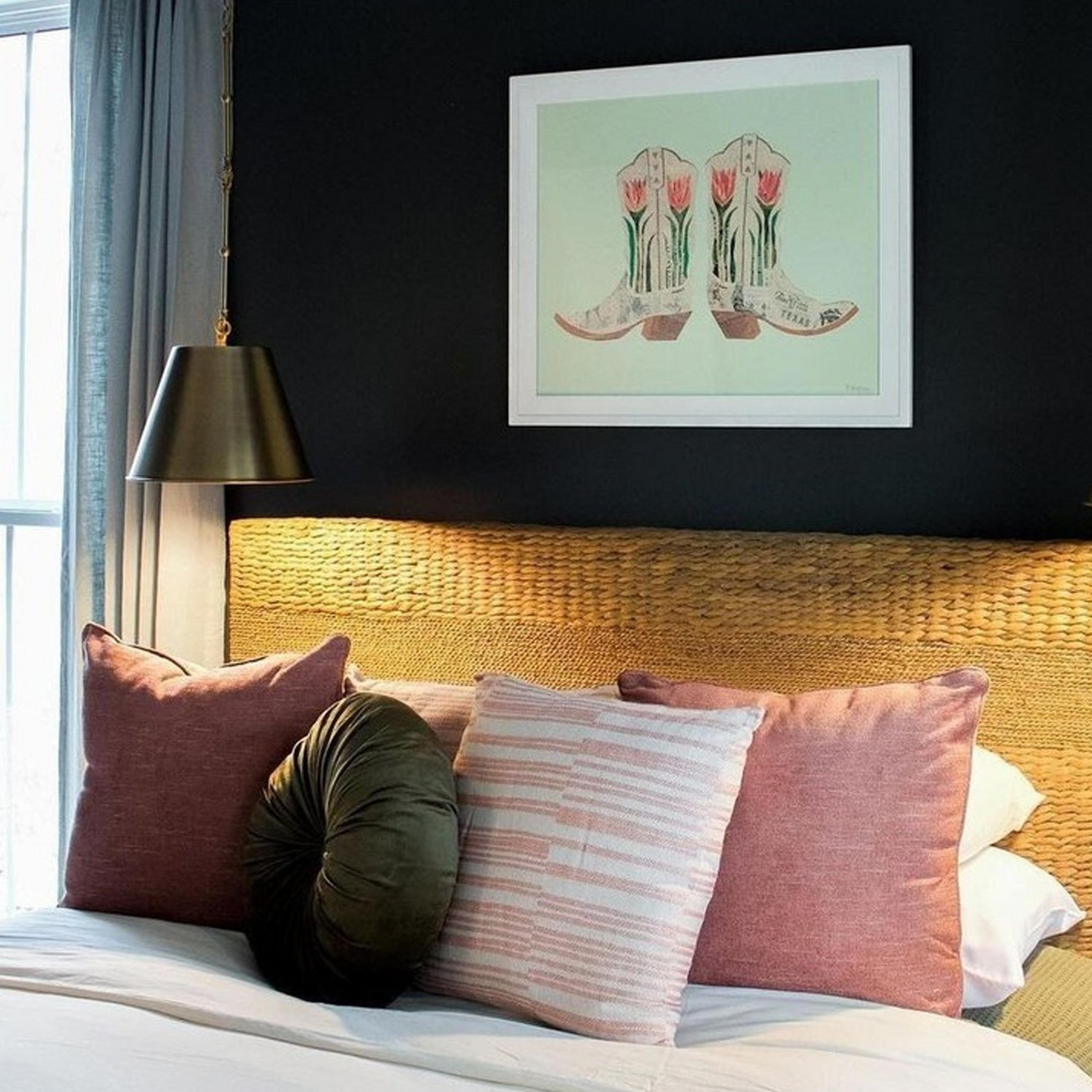 Small Modern Metal Shade Pendant hangs beside a bed with cowboy boot print on wall