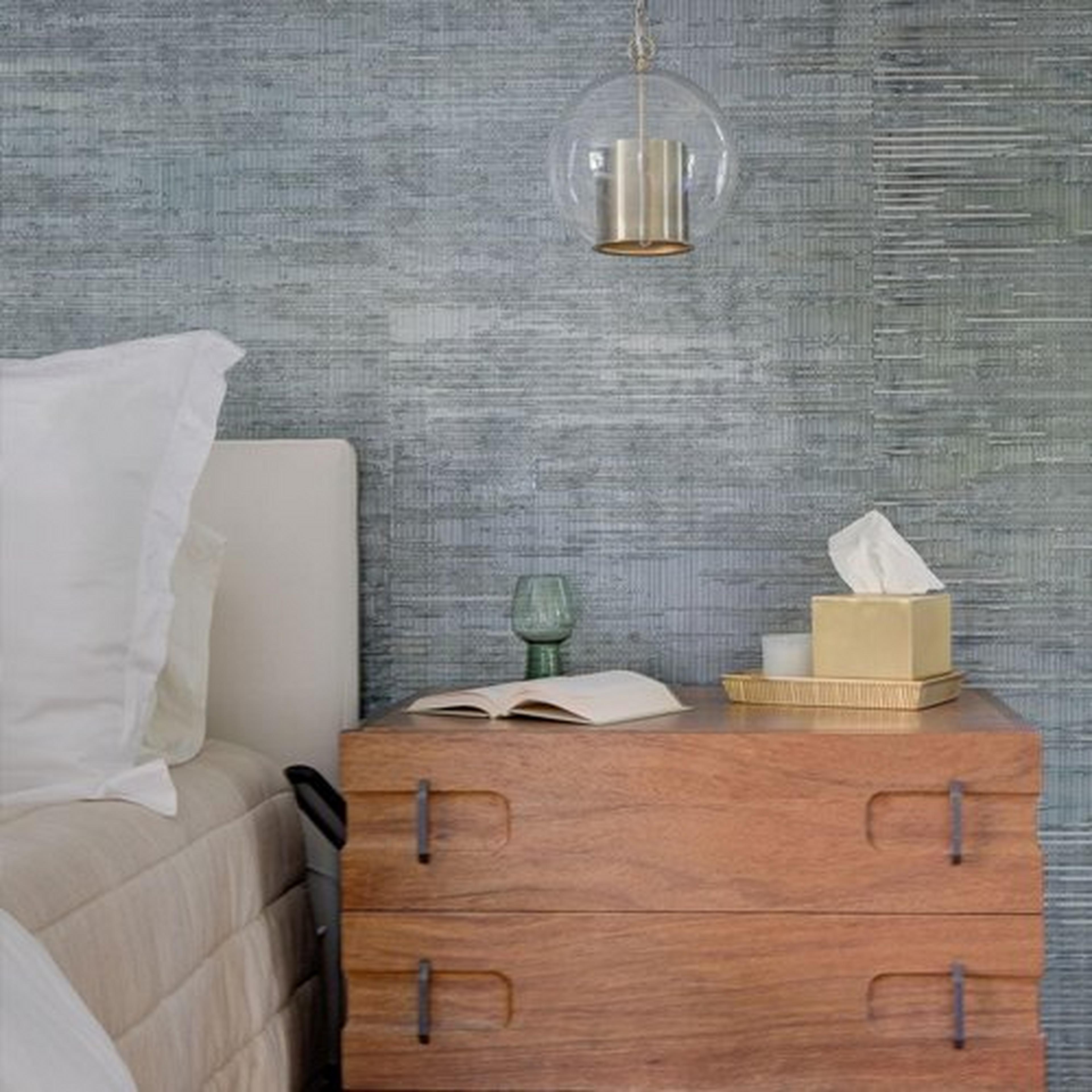 Cap and globe pendant hanging over a bedside table