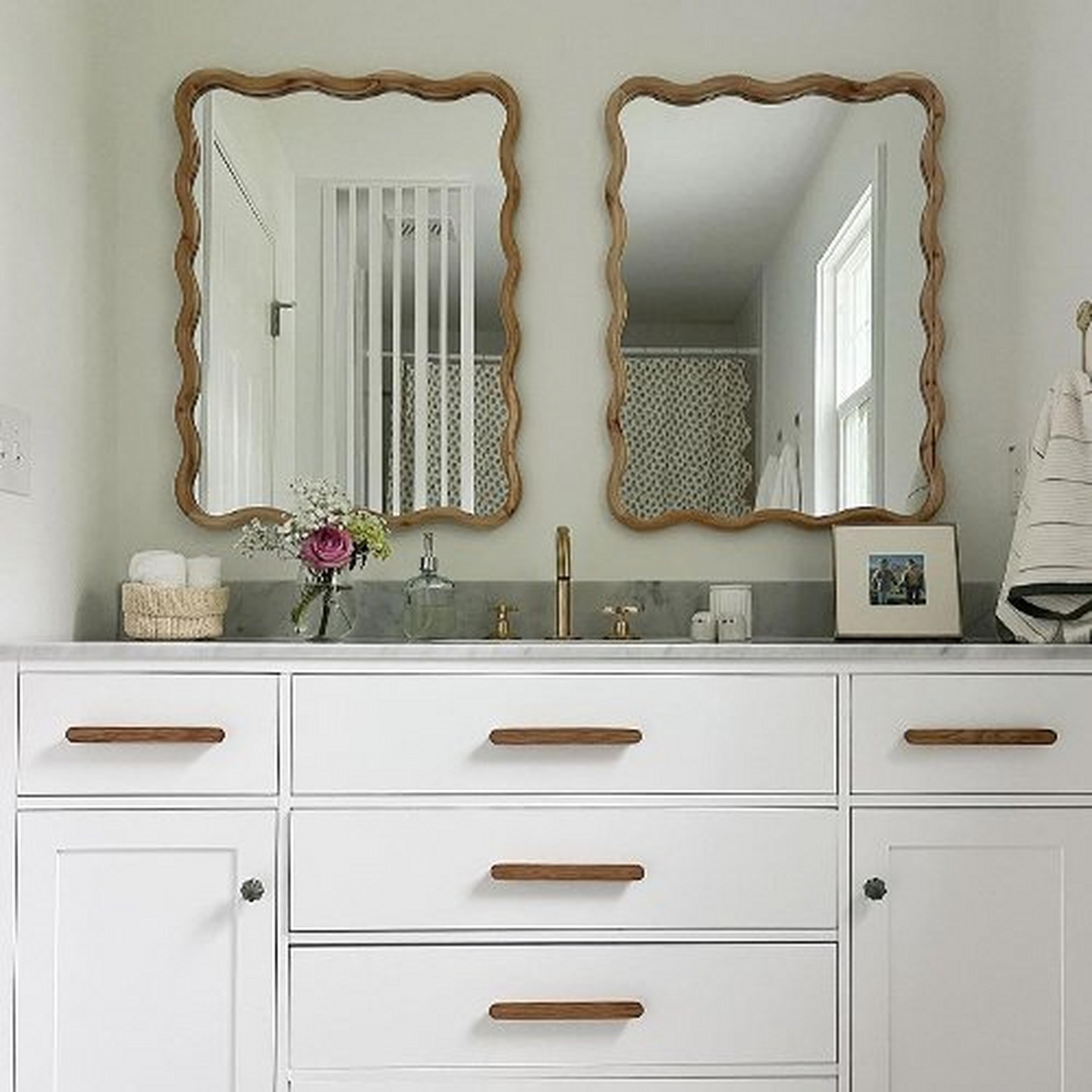 Two Olsen Squiggle Mirrors hang over a white bathroom vanity