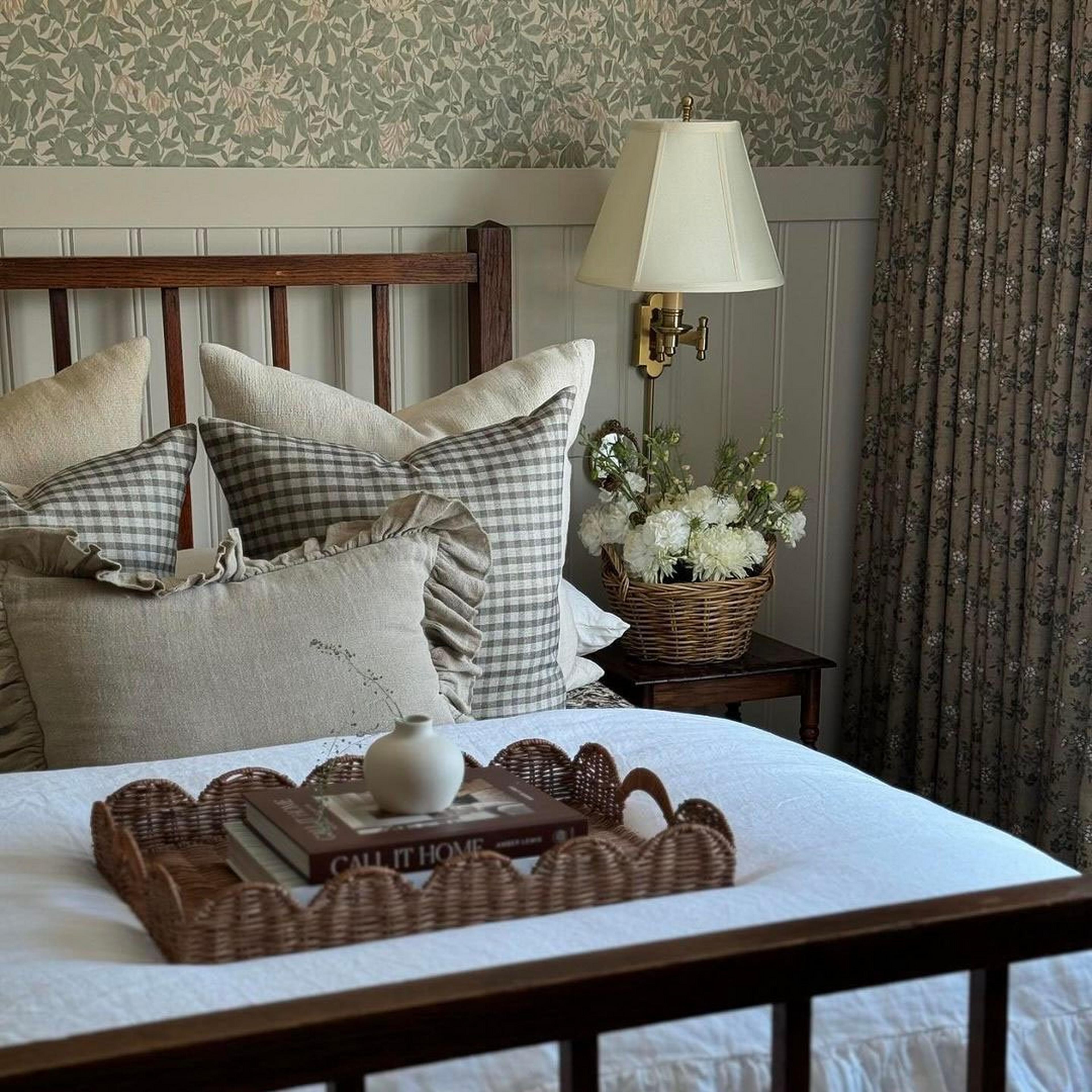 A traditional swing arm wall lamp beside a cottage core bed
