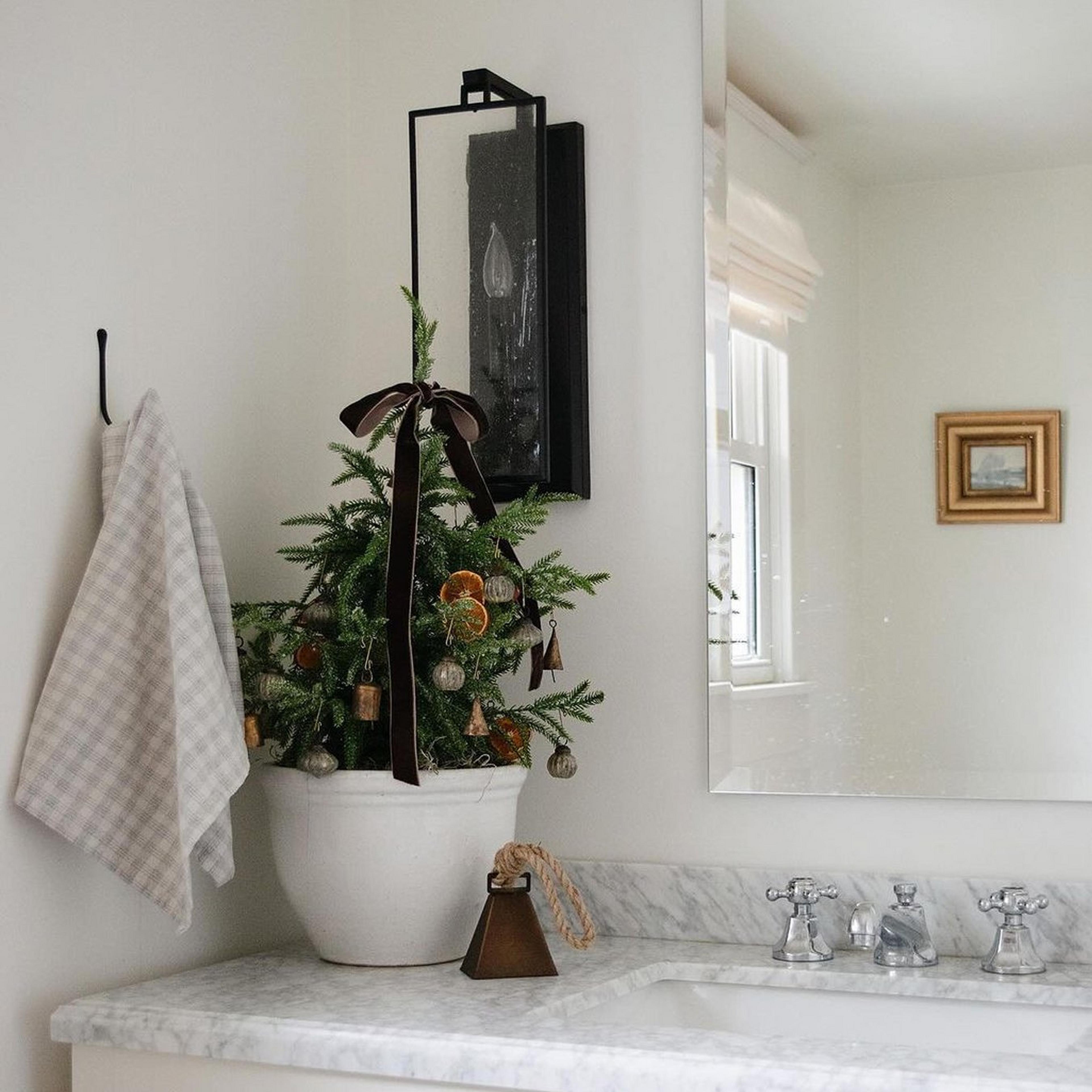 Matte black and antique glass Simply Black Sconce in bathroom with mini tree