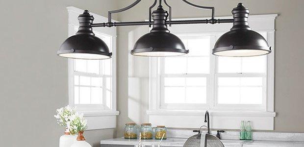 Black three light chandelier over a kitchen island