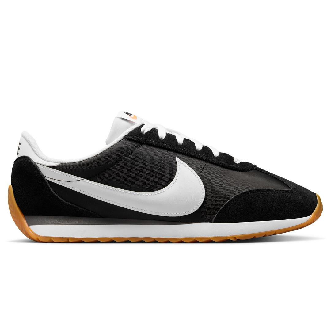 Low-profile black sneaker with an oversized Nike Swoosh logo at the side in white, along with a contrast white stripe along the side sole, just above a gum rubber outsole that wraps up to the toe and heel. Contrast white laces at the top. follows 2025 back to school fashion trends