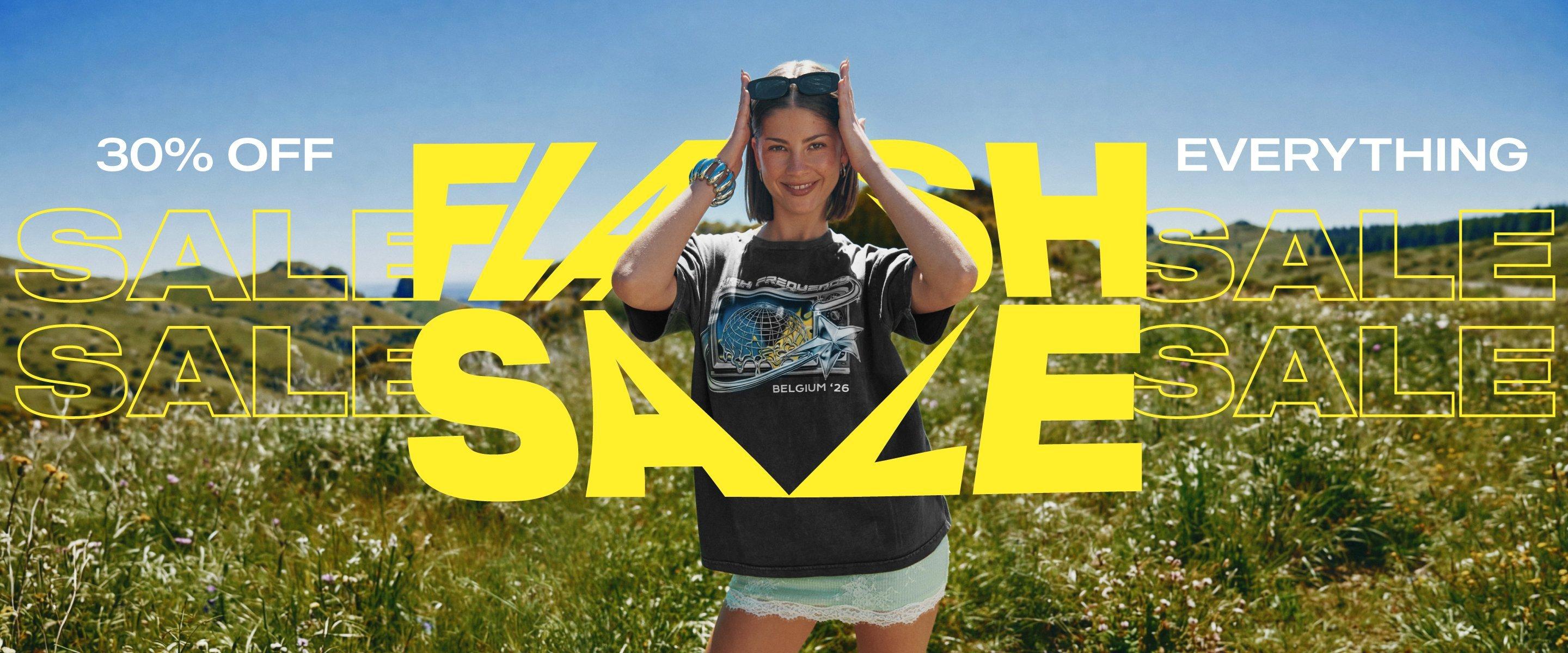 Wearing a printed T-shirt and sunglasses, a smiling woman stands in a field with the promotional text 30% off everything, Flash Sale.