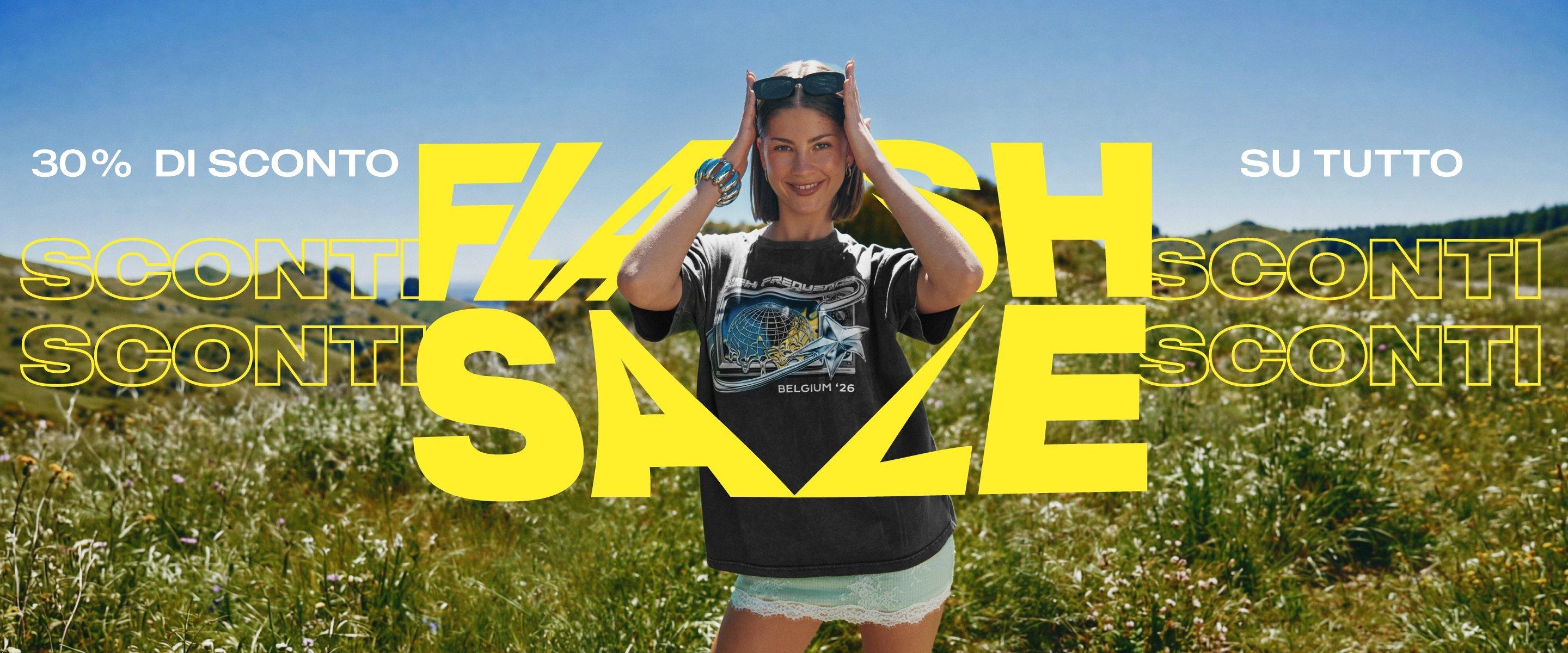 Indossando una t-shirt stampata e occhiali da sole, una donna sorridente è in piedi in un campo con il testo promozionale 30% di sconto su tutto, Vendita flash.