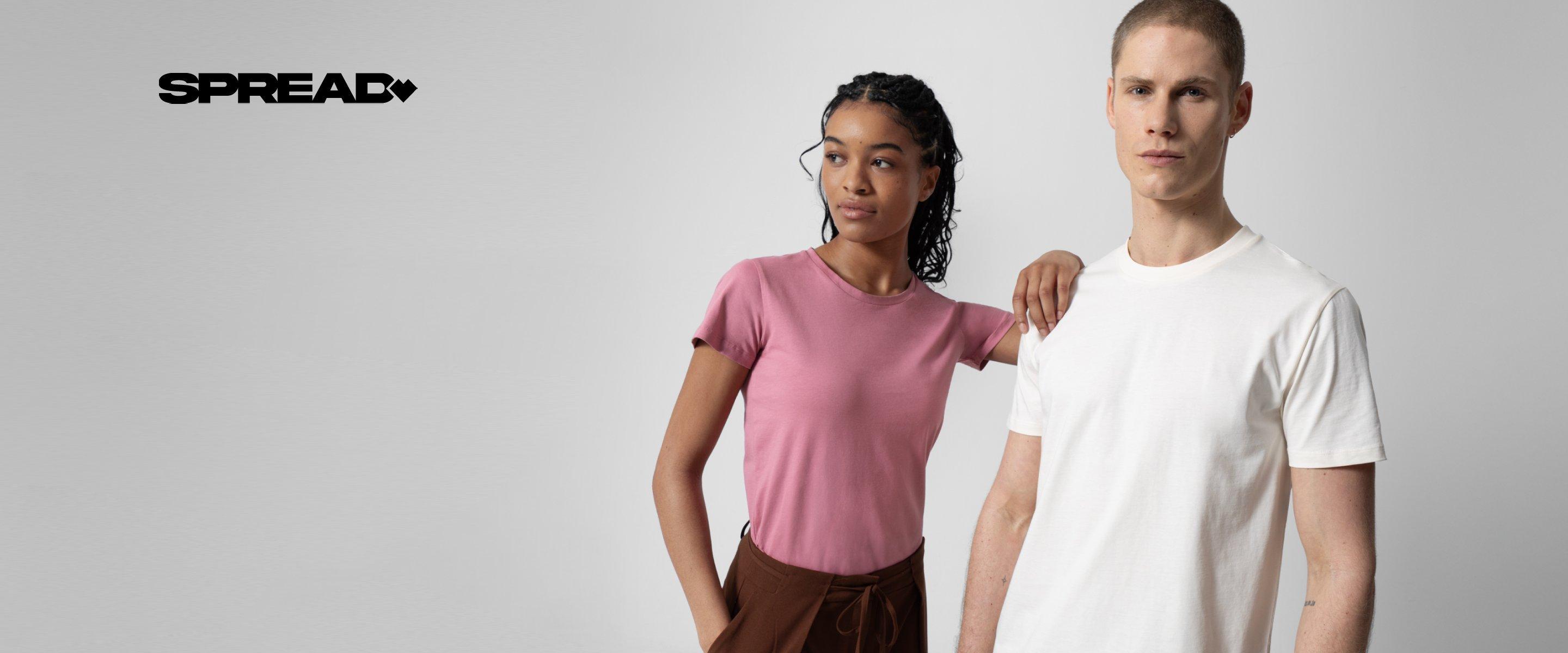Ein Mädchen in einem pinken T-Shirt beugt sich über einen Mann in einem weißen T-Shirt, beide vor grauem Hintergrund.