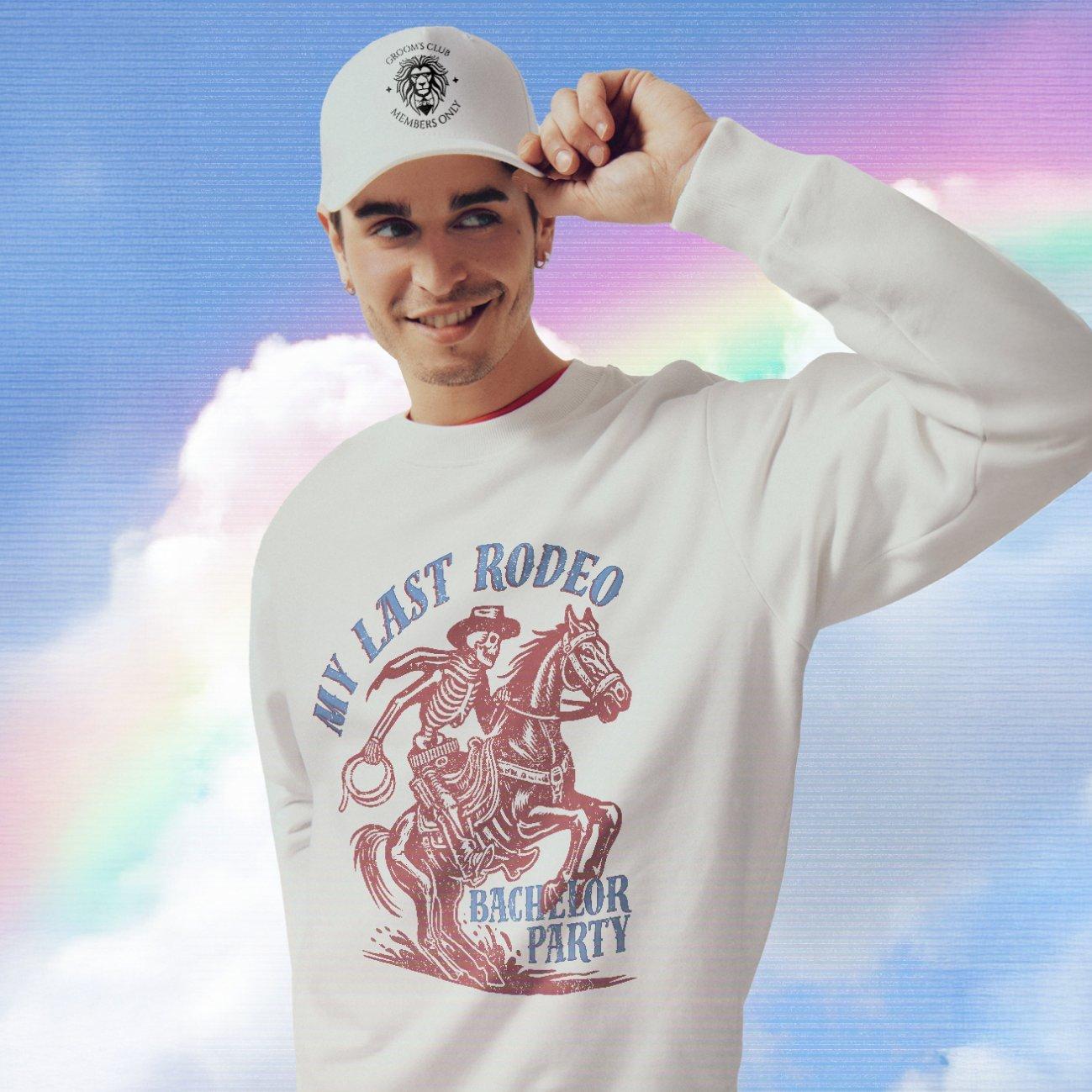 Joven frente a un fondo azul claro con nubes, con gorra blanca con estampado negro y sudadera blanca con un gran estampado gráfico rojo y letras azules.