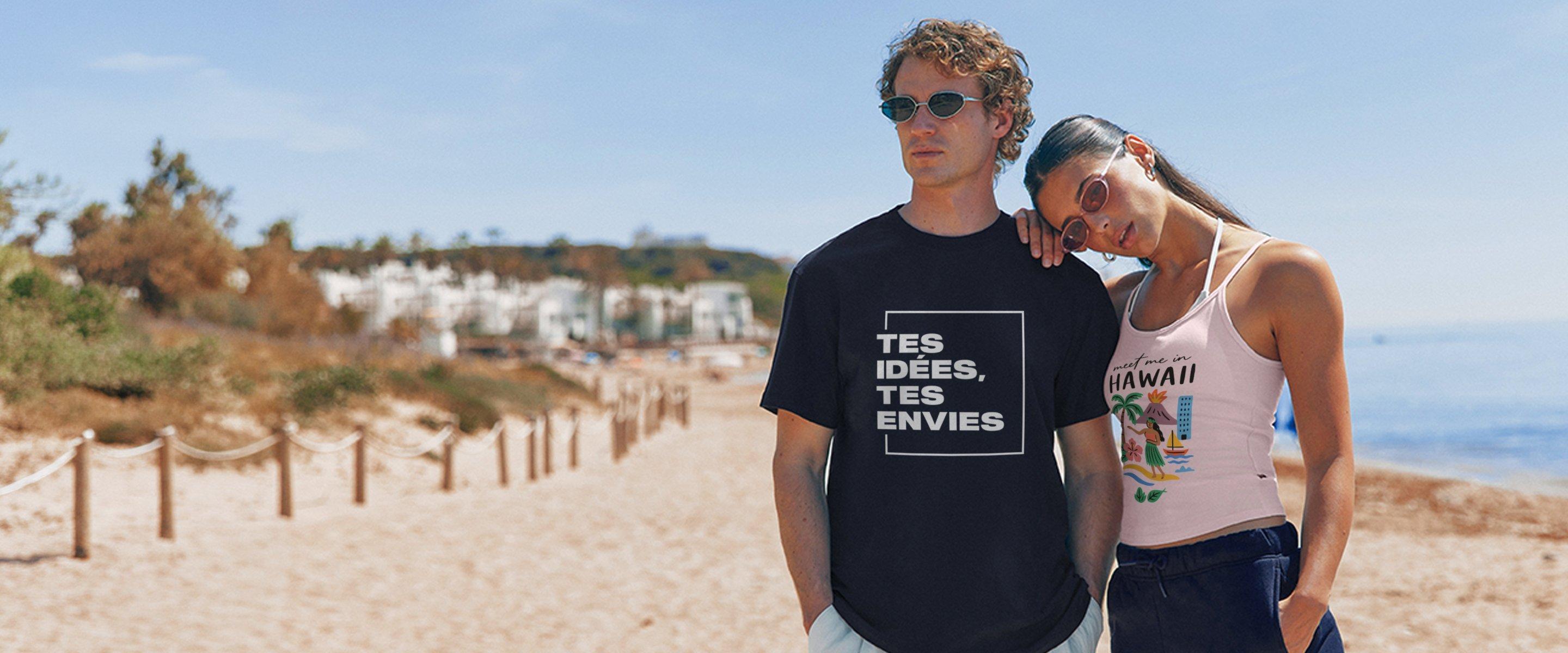 Un homme porte un t-shirt noir avec le texte « Tes idées, tes envies » tandis qu’une femme porte un top rose avec motif estival sur une plage.