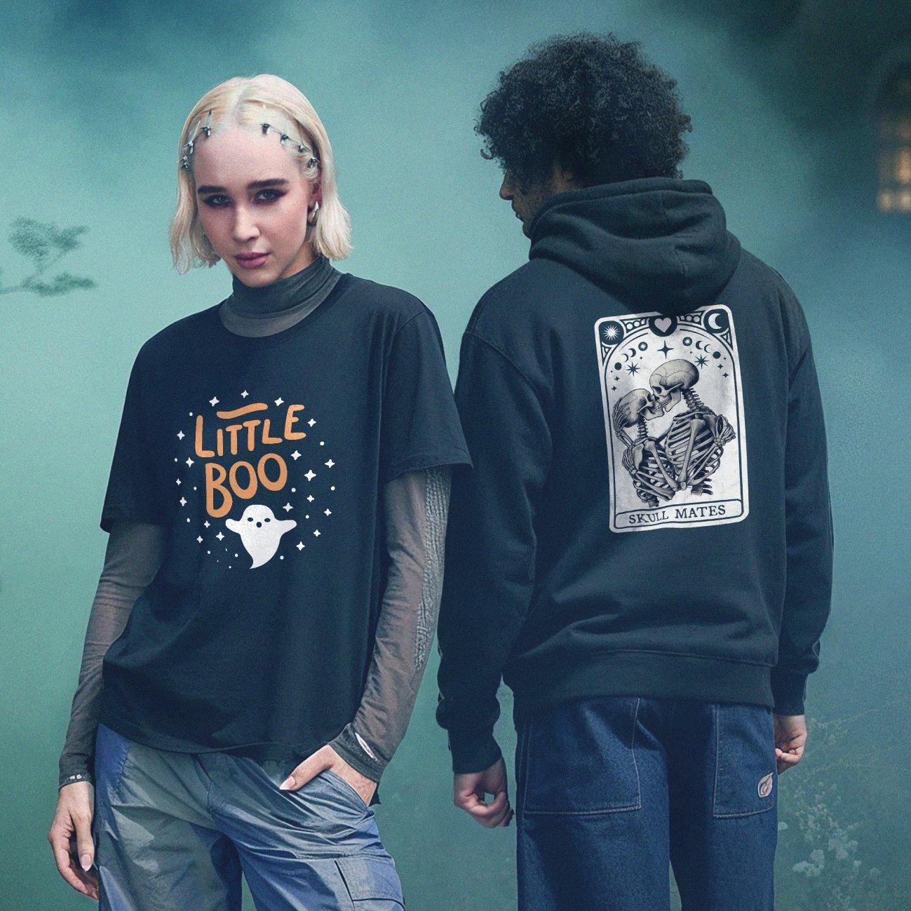 Twee mensen, op de voorgrond een vrouw met een zwart 'Little Boo' T-shirt , op de achtergrond een man in een zwarte hoodie met een skeletillustratie.