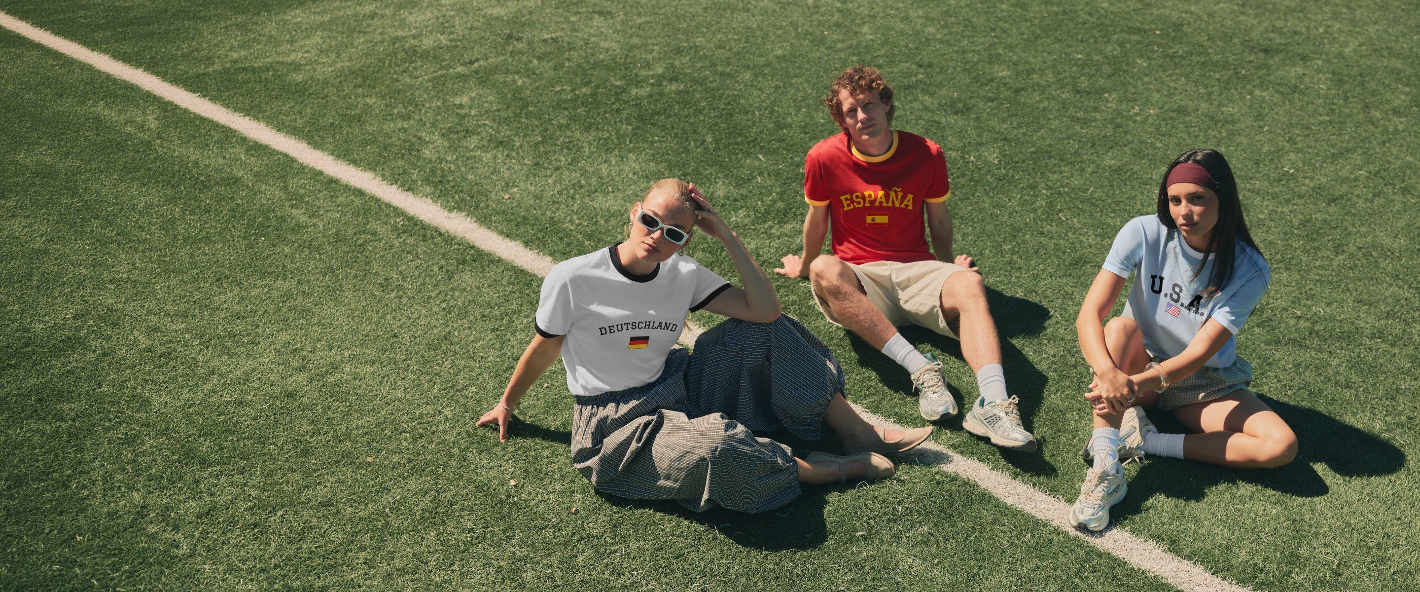 Trois personnes sont assises sur un terrain de football en portant des maillots de football.
