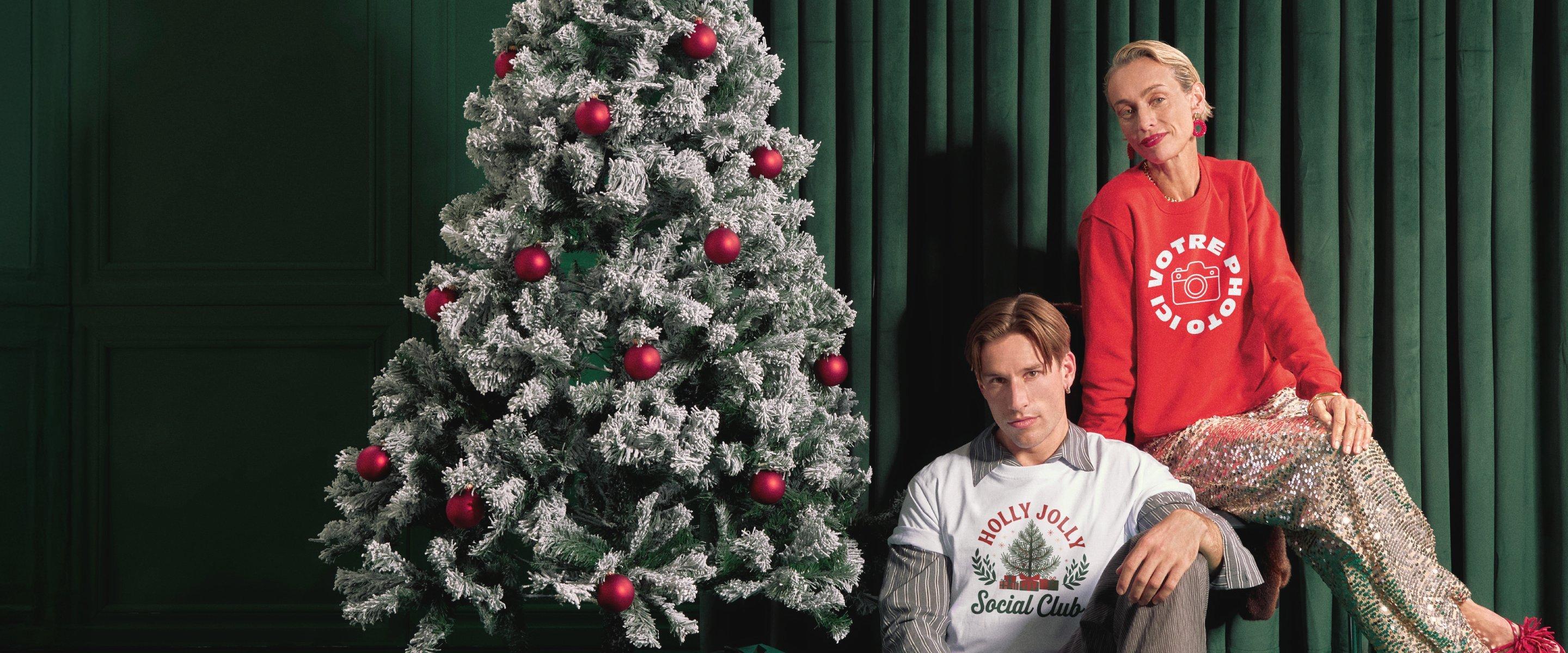 Un homme et une femme posent devant un sapin de Noël, portant des pulls avec le texte « Votre photo ici ».