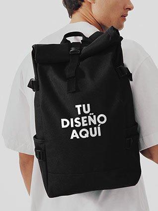 Hombre lleva una mochila negra con la inscripción "Tu diseño aquí".