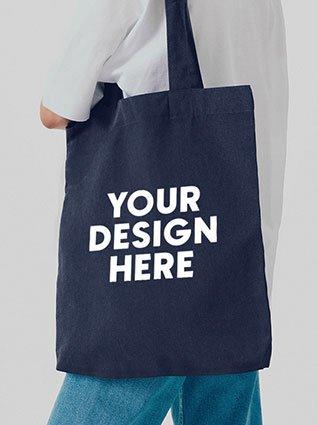 Person carries dark blue cloth bag with white print in the center saying "Your design here."