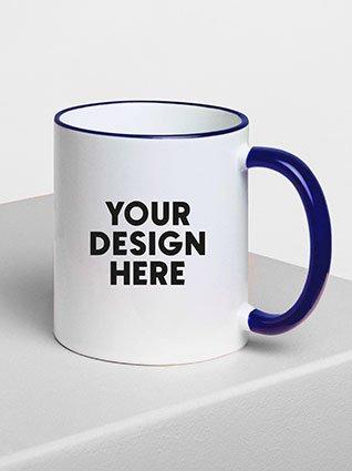 White ceramic mug with blue handle, black "Your design here" print on the front.