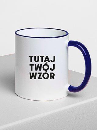 Biały kubek ceramiczny z niebieskim uchwytem, czarny nadruk „Twój wzór tutaj” z przodu.