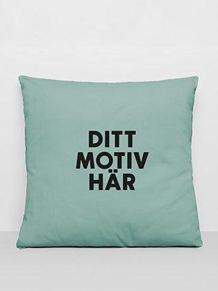 Kvadratisk pute i mintgrønn, med svart påtrykk «Ditt motiv her» i midten.