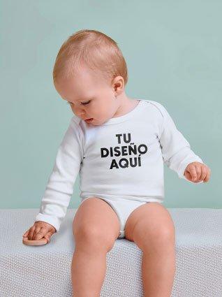 Bebé sentado usando un body blanco de manga larga con la frase "TU DISEÑO AQUÍ" impresa en el frente