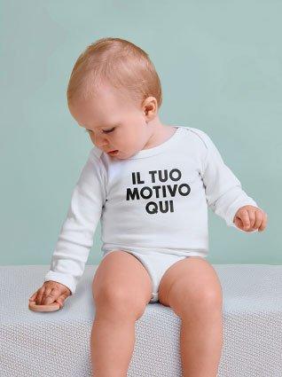 Bambino con body bianco a maniche lunghe con stampa nera "Il tuo motivo qui" seduto e guardando verso il basso.