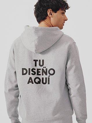 Hombre usando sudadera rosa con capucha y la frase "TU DISEÑO AQUÍ" impresa en el frente