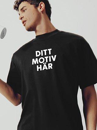 Man bär svart T-shirt med texten "Ditt motiv här".