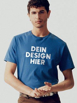 Mann trägt blaues T-Shirt mit weißem Aufdruck „Dein Design hier“ vorne.