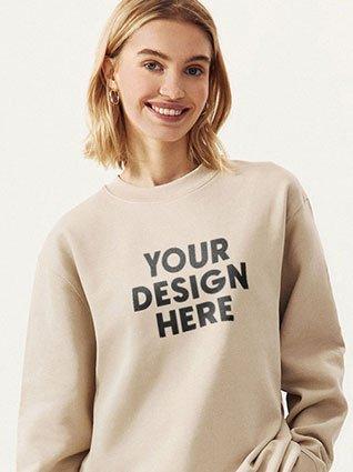 Woman smiles in a beige sweatshirt with black print "Your design here."