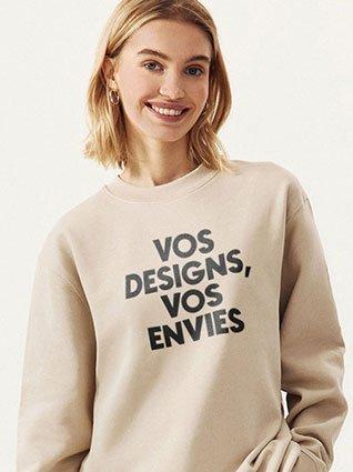Femme souriante en sweat beige avec l’impression noire « Vos idées, vos envies ».