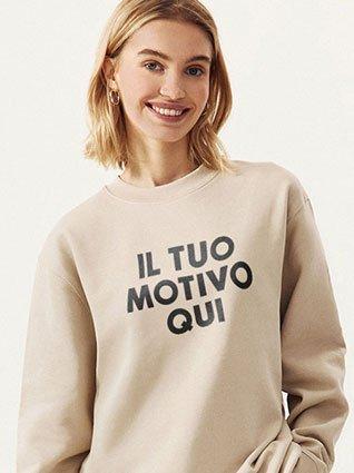 Donna sorridente con felpa beige con stampa nera "Il tuo motivo qui".