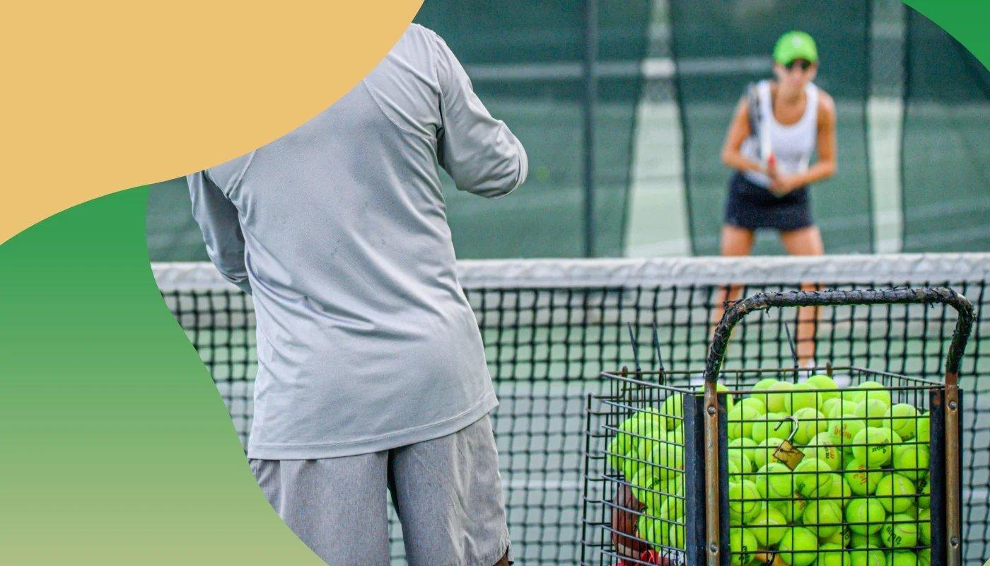Zwei Personen auf einem Tennisplatz beim Training, im Vordergrund ein großer Korb voller gelber Tennisbälle.