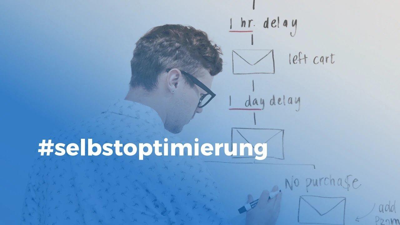 Mann mit gemsutertem Hemd und Brille steht mit dem Rücken zur Kamera vor einem Whiteboard und Skizziert eine Mailing-Customer-Journey - dazu der Hashtag selbstoptimierung.