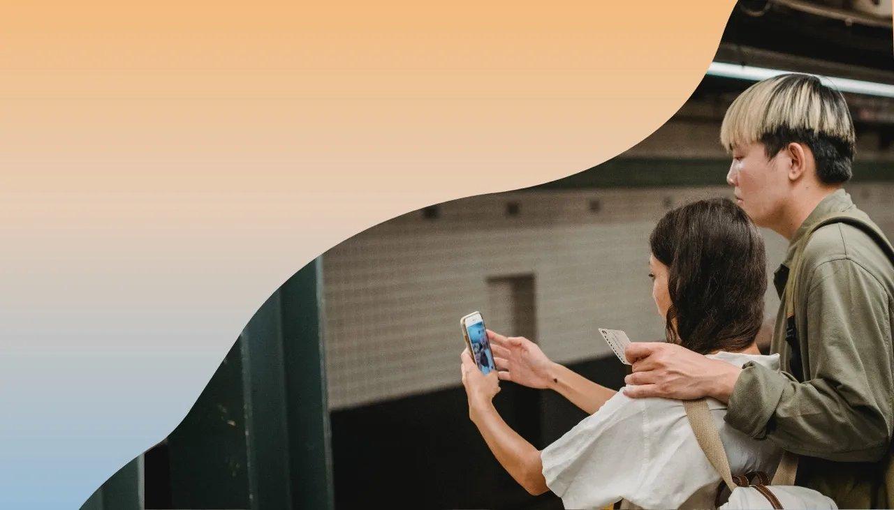 Zwei Jugendliche stehen an einer U-Bahn Haltestelle und nehmen ein Selfie auf.