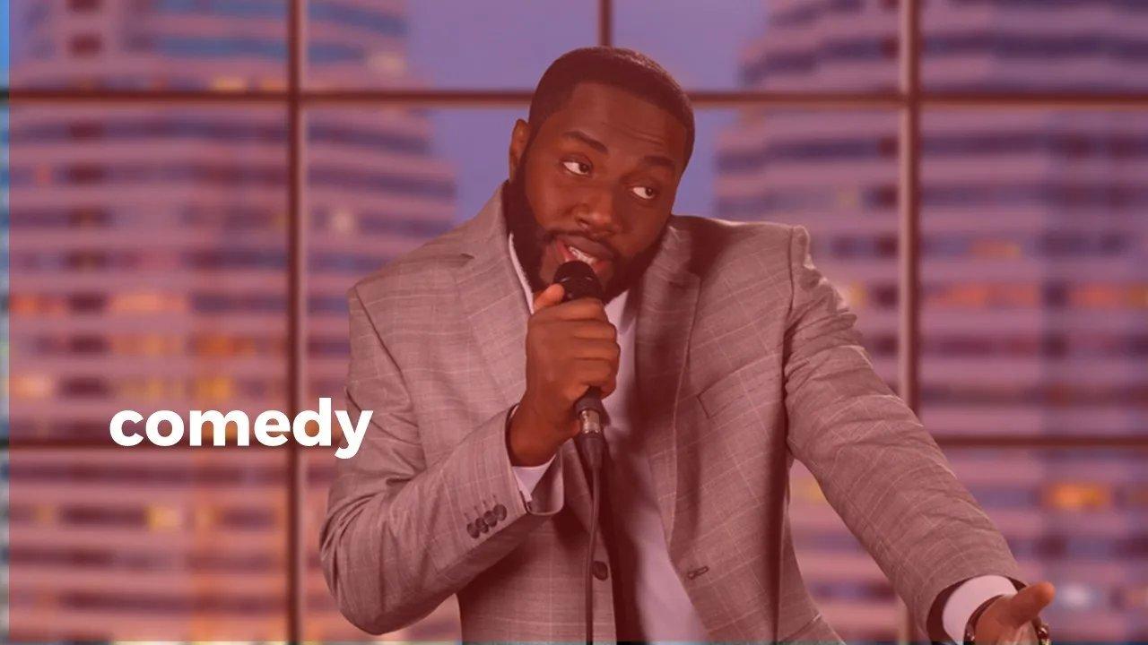 Person in einem Anzug auf der Bühne mit Mikrofon in der Hand erzählt eine Story.