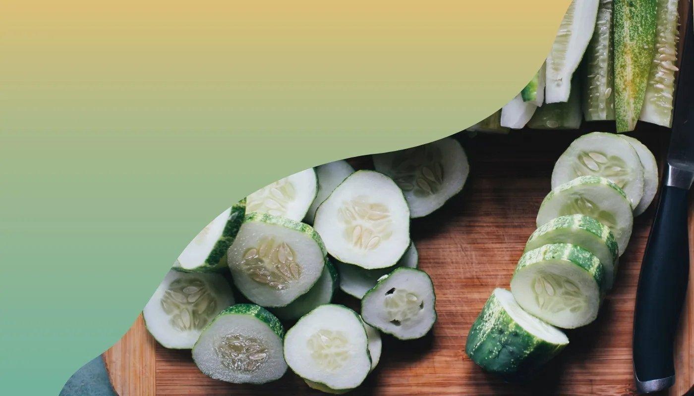 Scheiben einer Gurke auf einem Holzbrett, daneben ein Messer, visuell unterstützt durch grünen Farbverlauf.