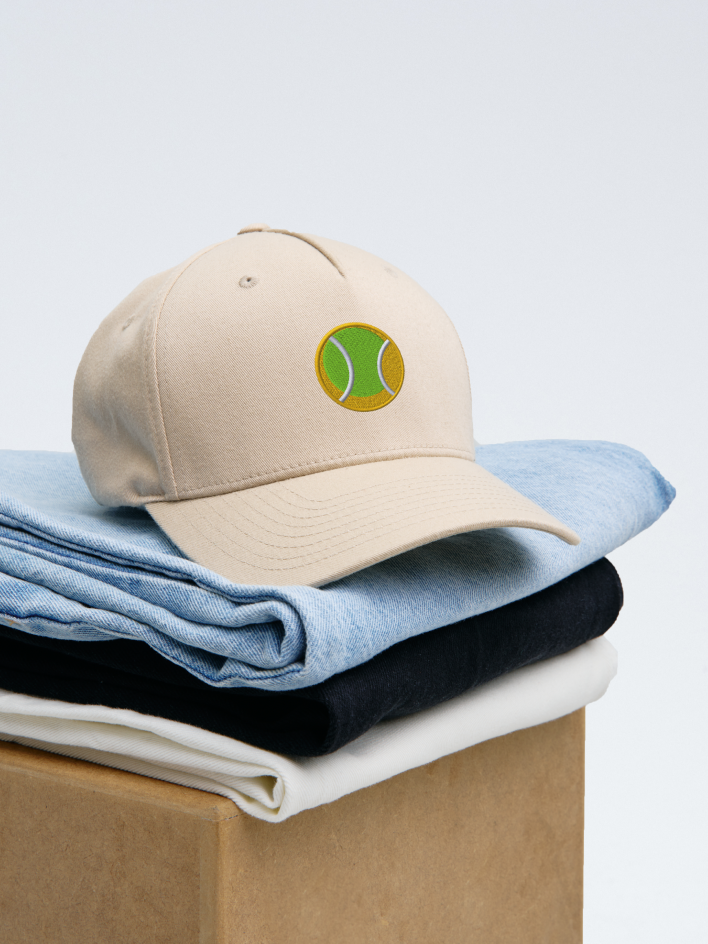 baseball cap with an embroidered tennis ball design