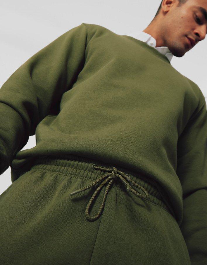 Mann mit matching Sweatshirt und Jogginghose in khaki.