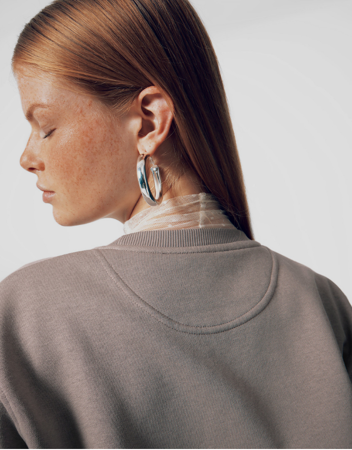 Femme vue de dos portant un sweat gris premium