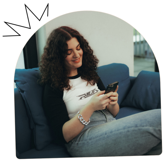 photo of a spreadshop user wearing a custom shirt and making designs on their phone