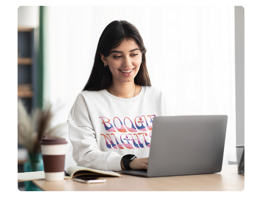 girl wearing a custom sweatshirt using her laptop to illustrate ease of shop navigation