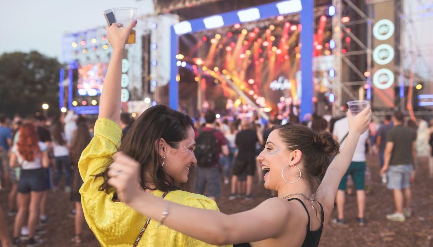 Festival attendees enjoying live music while wearing festival outfits